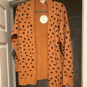 Orange with black spots. Super cute fall cardigan! Size Large. Never worn!